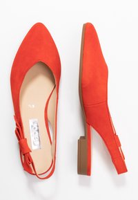 Red suede pointed-toe flats featuring a slingback design and a small block heel. Includes a bow accent on the side.