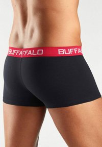 Black boxer shorts with a red elastic waistband featuring the text "BUFFALO." The material appears smooth and stretchy.