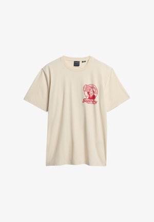 Beige T-Shirt mit kurzen Ärmeln und rotem Grafikdesign eines Mannes, der einen Stamm trägt, sowie dem Text "Superdry Quality Lumber" auf der linken Brust.