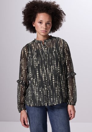 Schwarze durchsichtige Bluse mit einem gemusterten hellbeigen Design, ausgestattet mit einem Rüschenkragen, einer Knopfleiste und langen Ärmeln mit gerafften Manschetten.