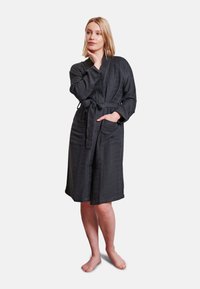 Mörkgrå badrock med en texturerad mönster, bälte i midjan, långa ärmar och två framfickor, tillverkad av mjukt och bekvämt tyg.