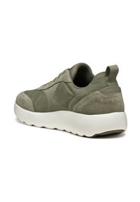 Zapatilla de color verde aceituna que combina gamuza suave y tela texturizada, con una suela de goma blanca y una lengüeta en la parte trasera para facilitar su uso.