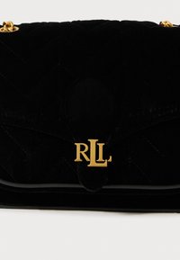 Melnas samta rokassomas ar izšūtām dizaina daļām, kurā atrodas zelta "RLL" logo un zelta ķēdes apdares detaļas. Kompakta, ar elegantu aizdares mehānismu.
