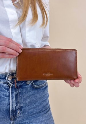 Pruun nahast rahakott sileda tekstuuri ja kontrastsete õmblustega, millel on lukuga tasku ja esiküljel reljeefne brändi logo.