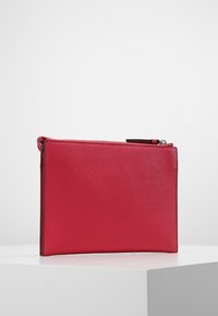 Red synthetic material pouch with a smooth texture, and a zip closure along the top edge. Simple rectangular shape, minimalistic design.