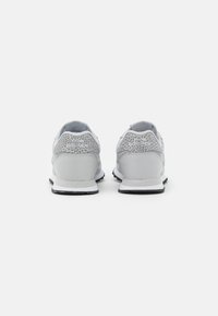 Gray athletic shoes featuring a textured heel and smooth midsection, with a white sole and black accents.