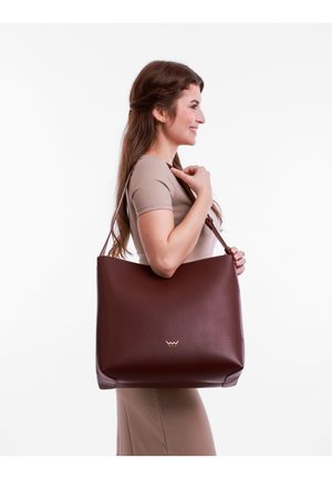 Braune Leder-Tote mit glatter Oberfläche, großem, offenem Design und subtiler Logo-Akzentuierung. Verfügt über lange, komfortable Schulterriemen.