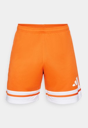 Pomarańczowe spodenki sportowe z gładką fakturą, elastyczną talią i białymi paskami na dole. Logo z trzema paskami w kolorze białym z boku.