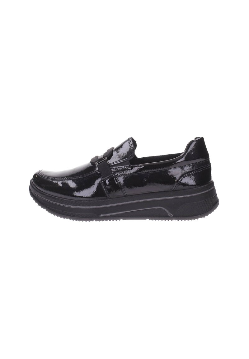 Zapato negro de cuero brillante, tipo slip-on, con suela de goma gruesa y tira decorativa con hebilla, perfil lateral sobre fondo blanco.