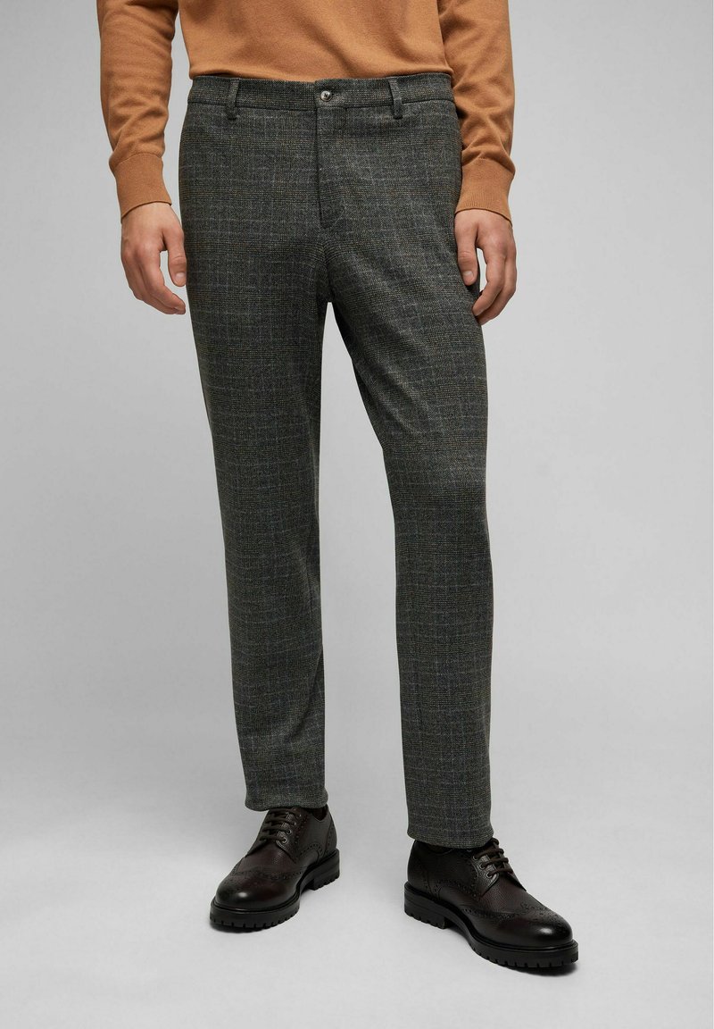 Grijze geruite broek van gestructureerde stof, met een ritssluiting, een knoop en zijzakken, gecombineerd met donkerbruine dresschoenen.