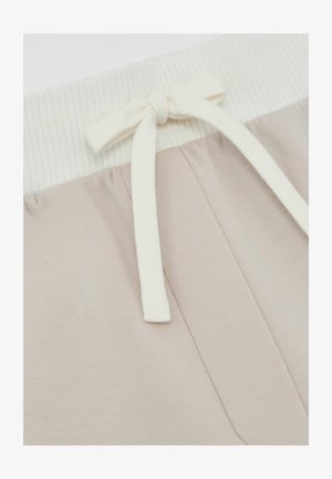 Hellbeige Sweatpants mit einem weichen, gerippten cremefarbenen Bund. Verfügt über eine passende Kordel und eine glatte Textur im gesamten Stoff.