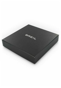 Caja de embalaje negra cuadrada con una textura suave, que presenta el texto en relieve de color blanco "BREIL" centrado en la tapa.