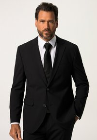 Completo nero con due bottoni, design monopetto, accompagnato da una camicia bianca e una cravatta nera. Tessuto liscio, vestibilità su misura.