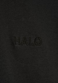Czarna bawełniana koszulka z haftowanym logo "HALO" w dopasowanym kolorze nitki, charakteryzująca się gładką teksturą i prostym designem.