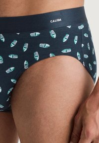 Herenboxers in donkerblauwe stof met een speels patroon van groene en witte botenmotieven. Voorzien van een contrasterende tailleband met merkopdruk.