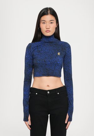 Skåret langærmet top i blå og sort mønster, med høj turtleneck og en lille logoaccent på brystet. Sæt sammen med sorte bukser.
