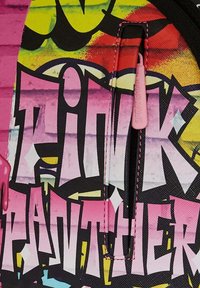 Zaino con un motivo colorato di graffiti in tonalità di rosa, giallo e nero. Dettagli notevoli includono una cerniera rosa e lettering distintivo.
