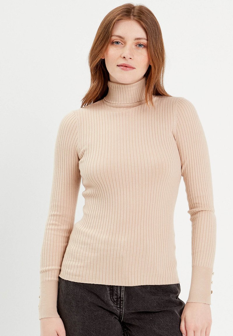 Suéter de cuello alto acanalado en color beige con mangas largas y detalles de botones en los puños, hecho de una suave tela de punto elástica.