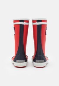 Red rubber rain boots with a smooth finish, featuring navy accents on the sides and white trim at the top and sole.