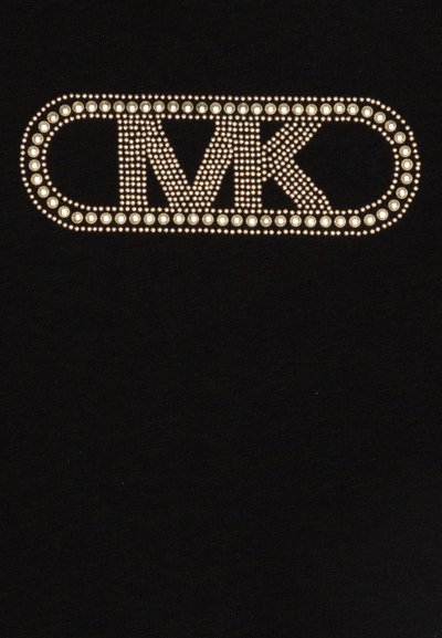 T-shirt noir avec un grand logo en relief orné de clous argentés "MK" centré dans un contour ovale. Texture de tissu lisse.