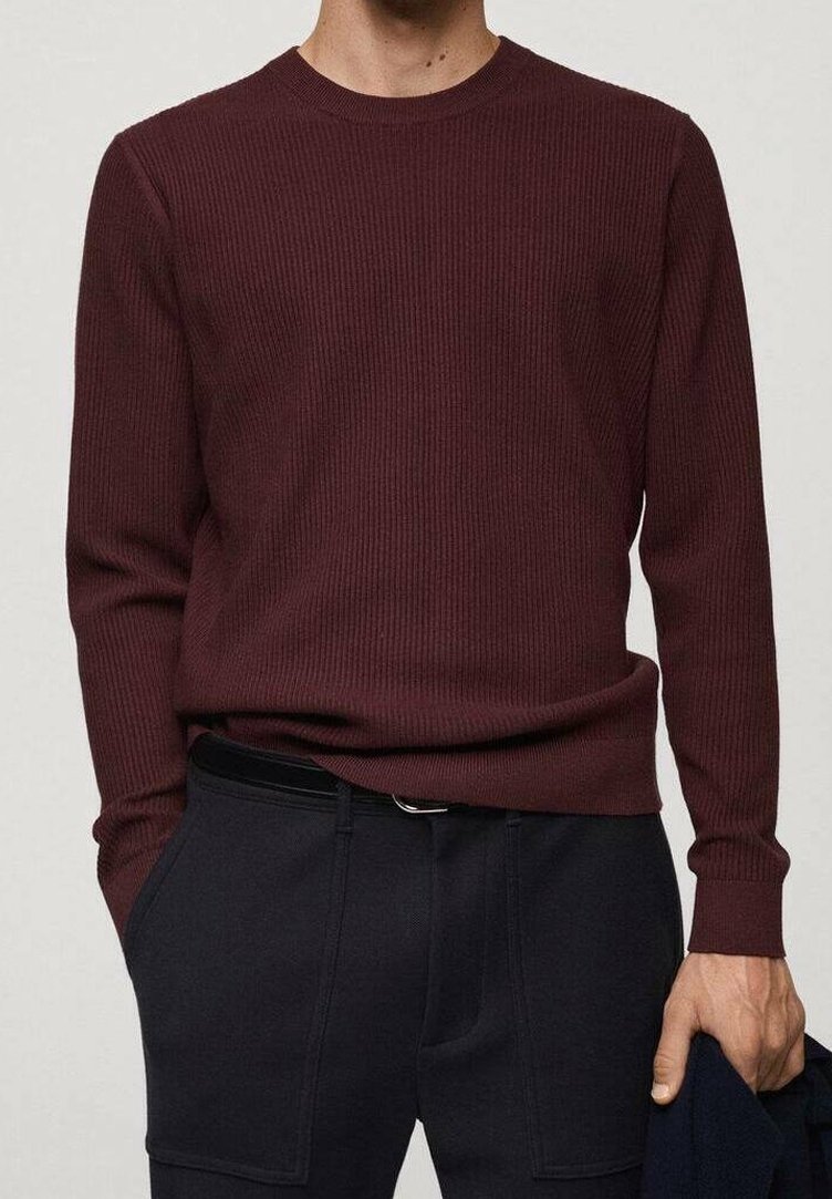 Pull bordeaux côtelé avec un col rond et des manches longues, en tissu maille texturé, associé à un pantalon foncé.
