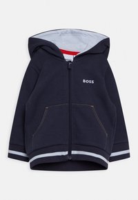 Navy zip-up hoodie i strukturerad tyg, med dragsko i huvan, framfickor och randiga ärmslut med kontrasterande sömmar.