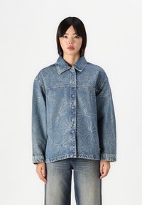 Jeans jakna v svetlo modri barvi, z gumbnim zapiranjem spredaj, koničastim ovratnikom in vezenimi cvetličnimi vzorci s srebrnimi akcenti.