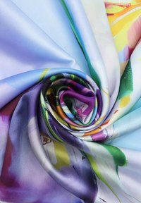 Tessuto di seta multicolore, caratterizzato da una texture liscia con vortici di viola, blu, verde e giallo in un motivo floreale. Aspetto morbido e lucido.
