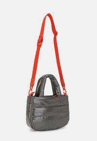 Borsa grigia lucida con superficie testurizzata, due manici corti e una tracolla rossa regolabile. Presenta cuciture orizzontali sulla parte anteriore.