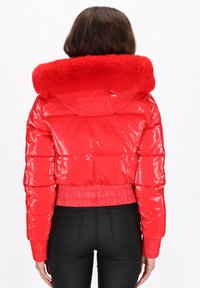 Czerwona błyszcząca kurtka typu puffer z kapturem obszytym sztucznym futrem, o skróconym kroju, z elastycznymi mankietami i pasem, z poziomymi przeszyciami.