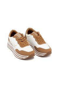 Baskets blanches et brunes avec une tige texturée, des rayures contrastées et des lacets ronds. Dotées d'un col rembourré et d'un détail de logo sur le côté.