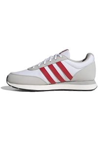 Männliche Sportschuhe in Weiß mit grauen Akzenten und drei roten Streifen. Sie verfügen über ein schlankes Design, eine Gummisohle und eine Schnürung.