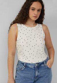 Mouwloze witte tanktop met zwarte stippen, geribbeld materiaal, ronde halslijn, gecombineerd met denim shorts met een voork pocket.