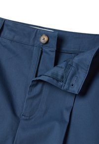 Marineblaue Baumwollmischhosen mit Knopfverschluss, verdecktem Reißverschluss, Seitentaschen, sauberer Naht und glatter Textur.