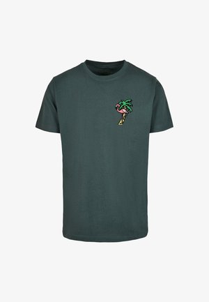 T-shirt in cotone verde scuro con una piccola grafica colorata di una palma e un fenicottero nell'area del petto sinistro. Maniche corte, collo rotondo.