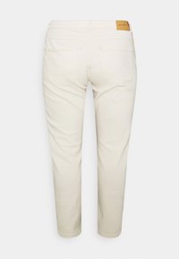 Vaaleanbeiget farkut, joissa on suora malli. Farkuissa on takanahkalappu vyötäröllä, kaksi takataskua ja sileä, kestävä kangas.