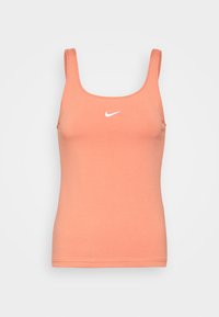 Persikofärgad linne i mjuk bomull, med rund halsringning och tunna axelband, prydd med en liten vit Nike-logotyp på bröstet.