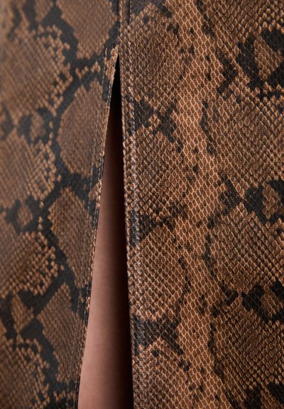 Bruine faux slangenhuidstof met een gestructureerd patroon, voorzien van een splitdetail. Heeft een gladde afwerking en een zwart accentontwerp.