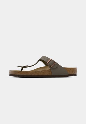 Olivgrüne Flip-Flop-Sandale mit Korkfußbett, gummierter Sohle und einer dekorativen Metallbuckle-Akzent am Riemen. Minimalistisches Design und Textur.
