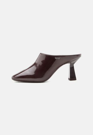 Mule marrone scuro lucido con punta appuntita, tacco a blocco e logo DKNY sul lato, esposto su uno sfondo bianco semplice.