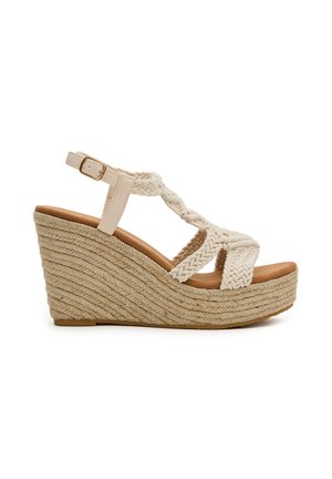 Sandalia cuña con correas trenzadas en crema y suela de cuerda beige. Cuenta con correa ajustable en el tobillo y plantilla texturizada para mayor comodidad.