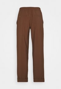 Brown trousers with a relaxed fit, elastic waistband, two back pockets, and cuffed hems. Smooth texture with no visible patterns.