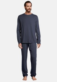 Navyblaue Langarmshirt und passende Hose aus weichem Stoff. Das Shirt hat einen Rundhalsausschnitt; die Hose hat einen elastischen Bund.