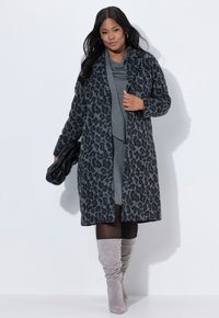 Cappotto grigio con stampa leopardata, dalla vestibilità comoda, con maniche lunghe, apertura anteriore e tessuto morbido. Abbinato a un vestito grigio e stivali alti fino al ginocchio grigi.
