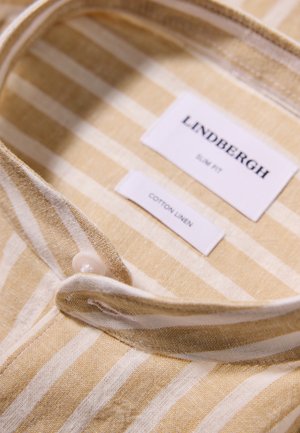Gul- og hvidstribet skjorte af bomulds-linned med krave og knaplukning. Mærkerne angiver mærke, pasform og stoftype. Strukturen af stoffet er synlig.