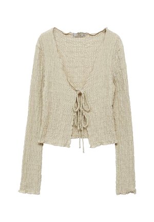 Cardigan corto beige, testurizzato, con maniche lunghe, scollatura a V e chiusura anteriore con nodo. Presenta un tessuto a coste con una finitura morbida.