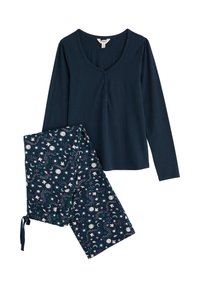 Námorně modrý top s dlouhým rukávem a detaily knoflíků, spárovaný s vzorovanými kalhotami s motivy měsíců, hvězd a květin v bílé a tyrkysové barvě.