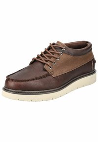 Zapato de cuero marrón y lona con punta redonda, suela de goma blanca y cierre de cordones. Presenta contrastes de texturas y detalles de costura.