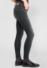 Zwarte stretch denim skinny jeans met vijf zakken, subtiele wassing, leren label op de achterkant van de tailleband en nauwsluitend bij de enkels.