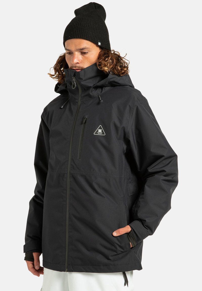 Czarna wodoodporna kurtka z wysokim kołnierzem, regulowanym kapturem, zamkiem z przodu i bocznymi kieszeniami. Zawiera trójkątny logo na klatce piersiowej.